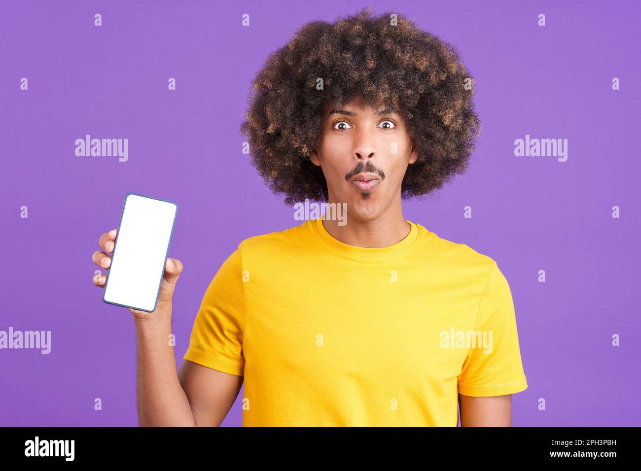 Surprised african man holding a mobile with a blank screen Stock Photo