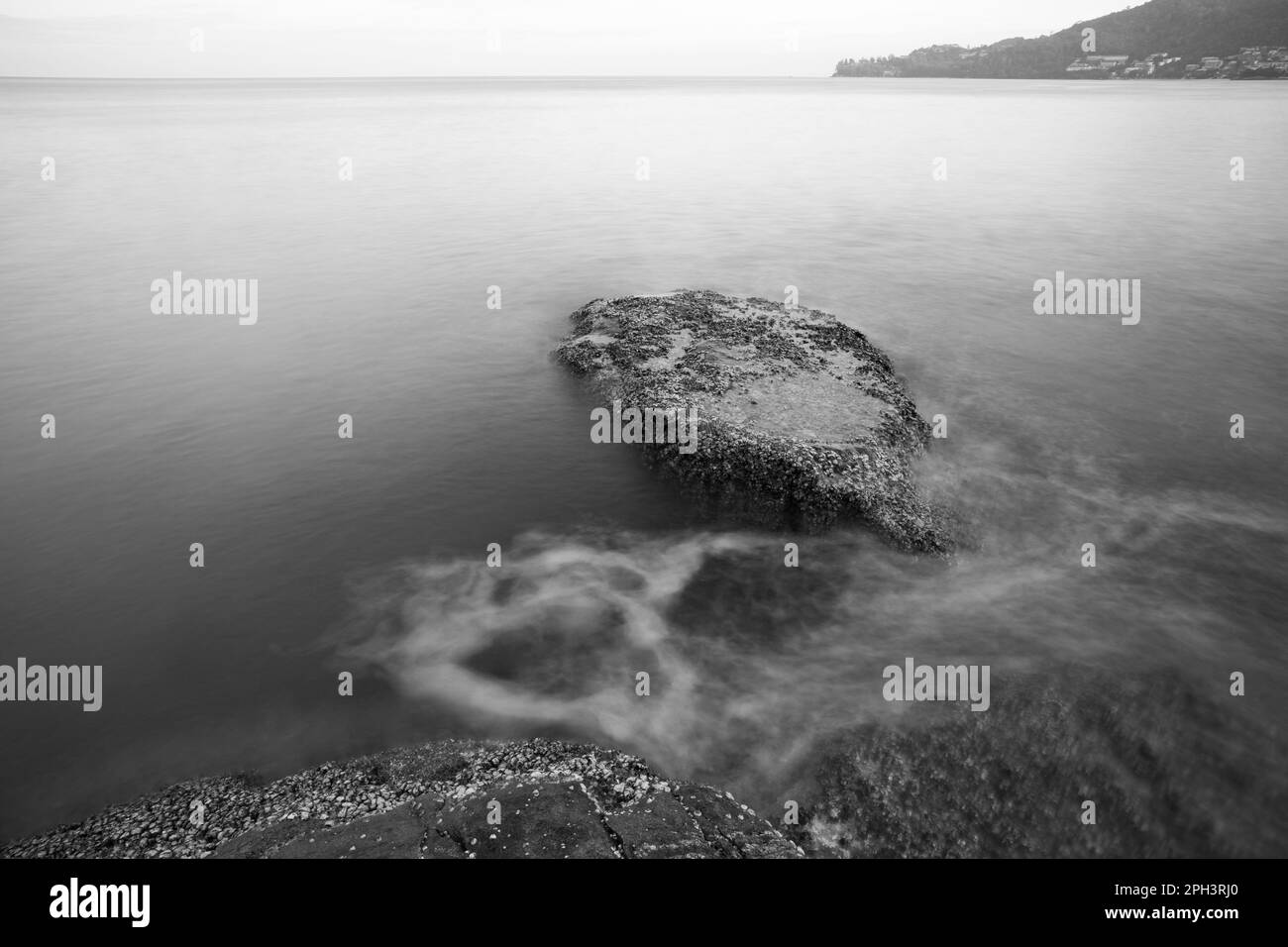 Waves over the rocks at the seashore in black and white Long exposure ...