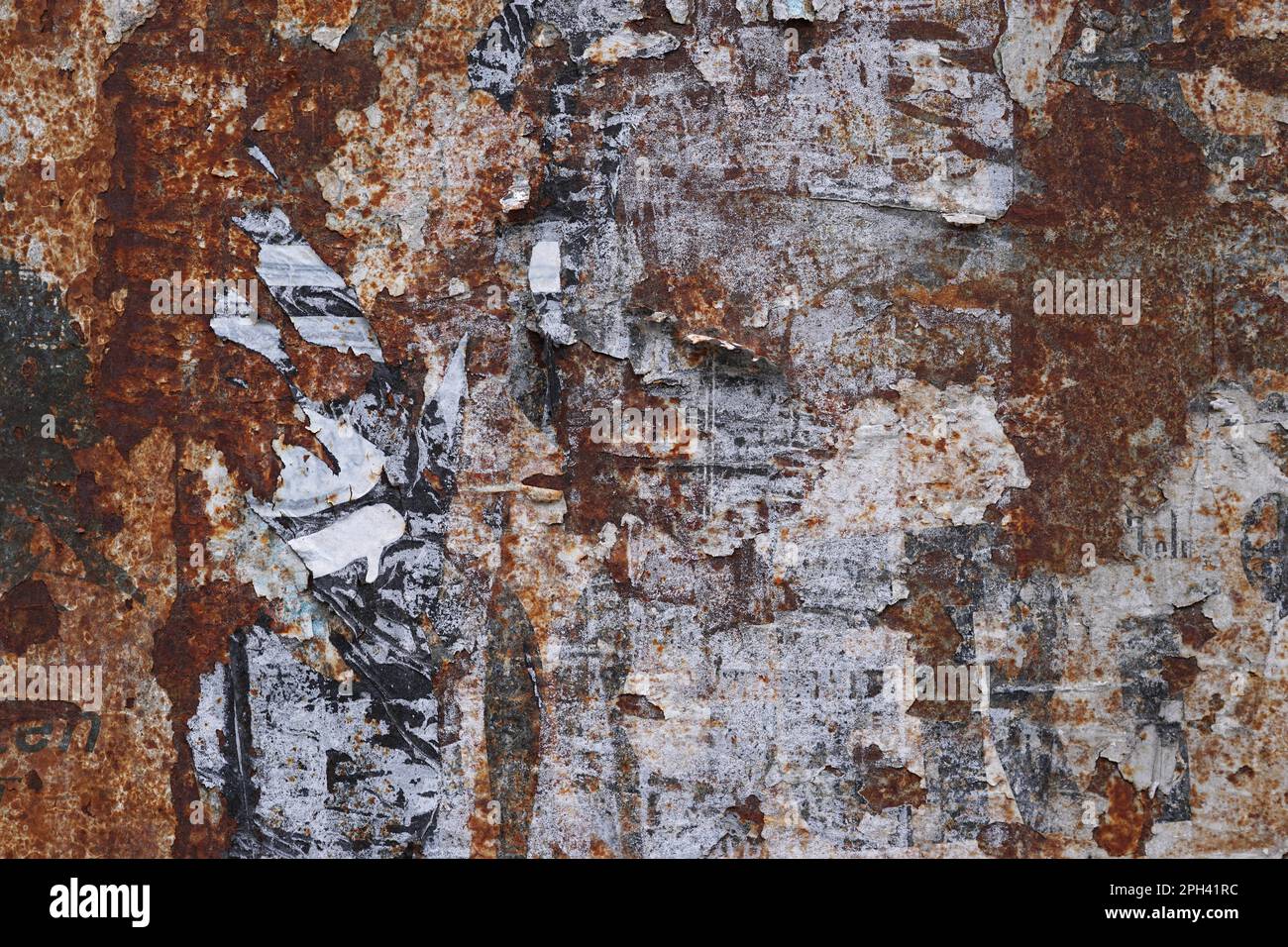rusty metal grunge background with peeling poster scraps Stock Photo