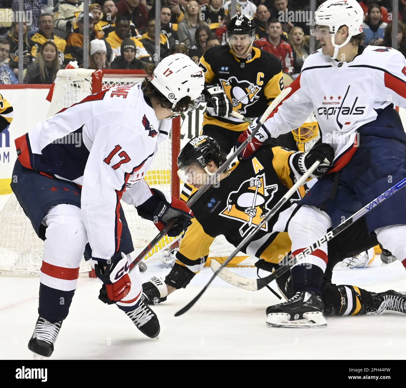 Pittsburgh, United States. 25th Mar, 2023. Washington Capitals right wing  Nicolas Aube-Kubel (96) knocks Pittsburgh Penguins defenseman Kris Letang  (58) to the ice as Washington Capitals center Dylan Strome (17) shoots and