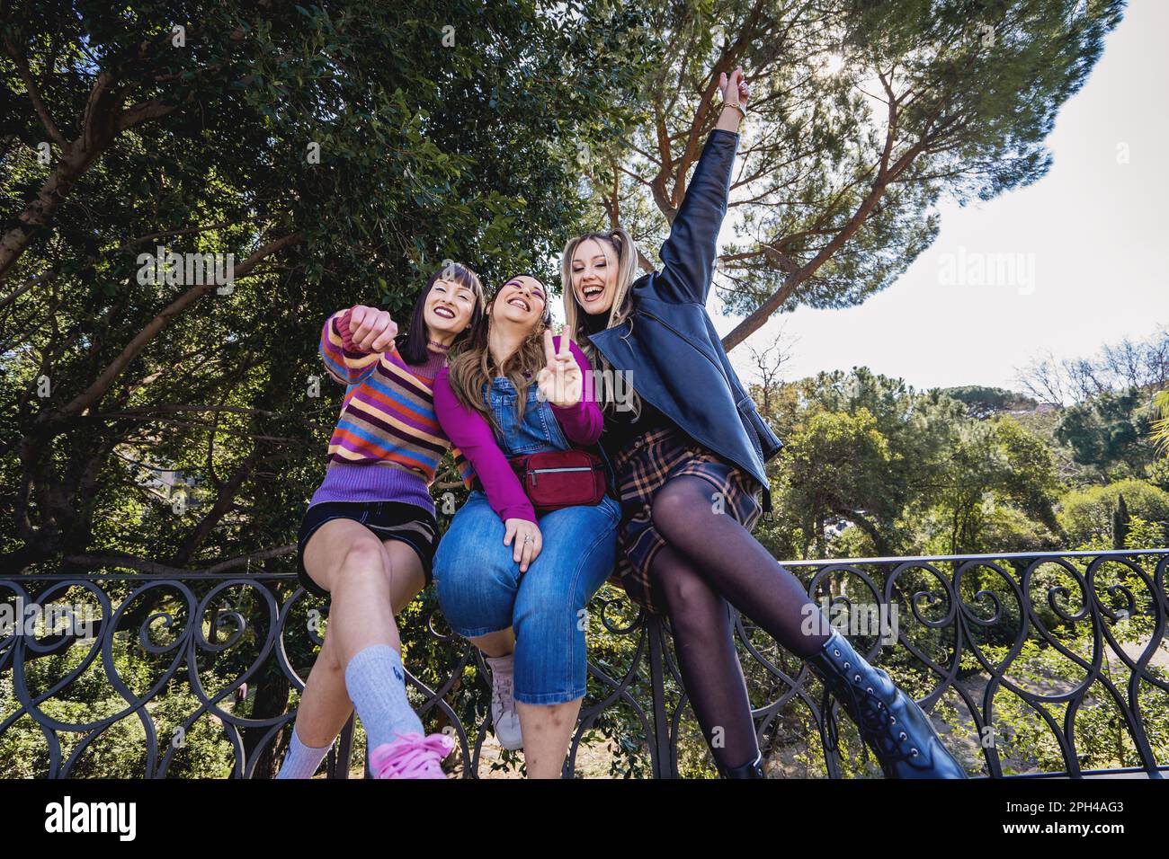 three-caucasian-women-in-90s-vintage-casual-outfits-sitting-on-a-park