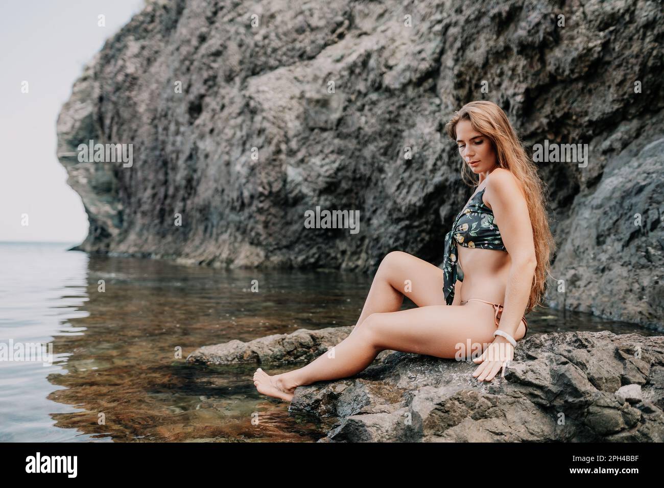 Woman travel sea. Happy tourist enjoy taking picture outdoors for memories. Woman traveler swim in the sea bay with mountains, sharing travel Stock Photo