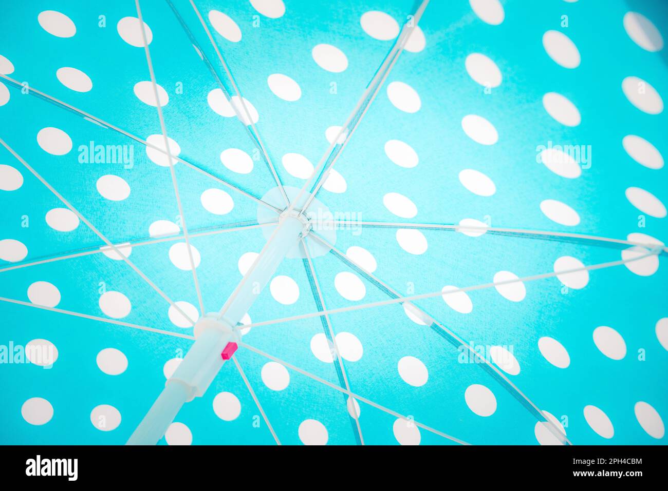 Close upward view of a blue dotted beach umbrella. Stock Photo
