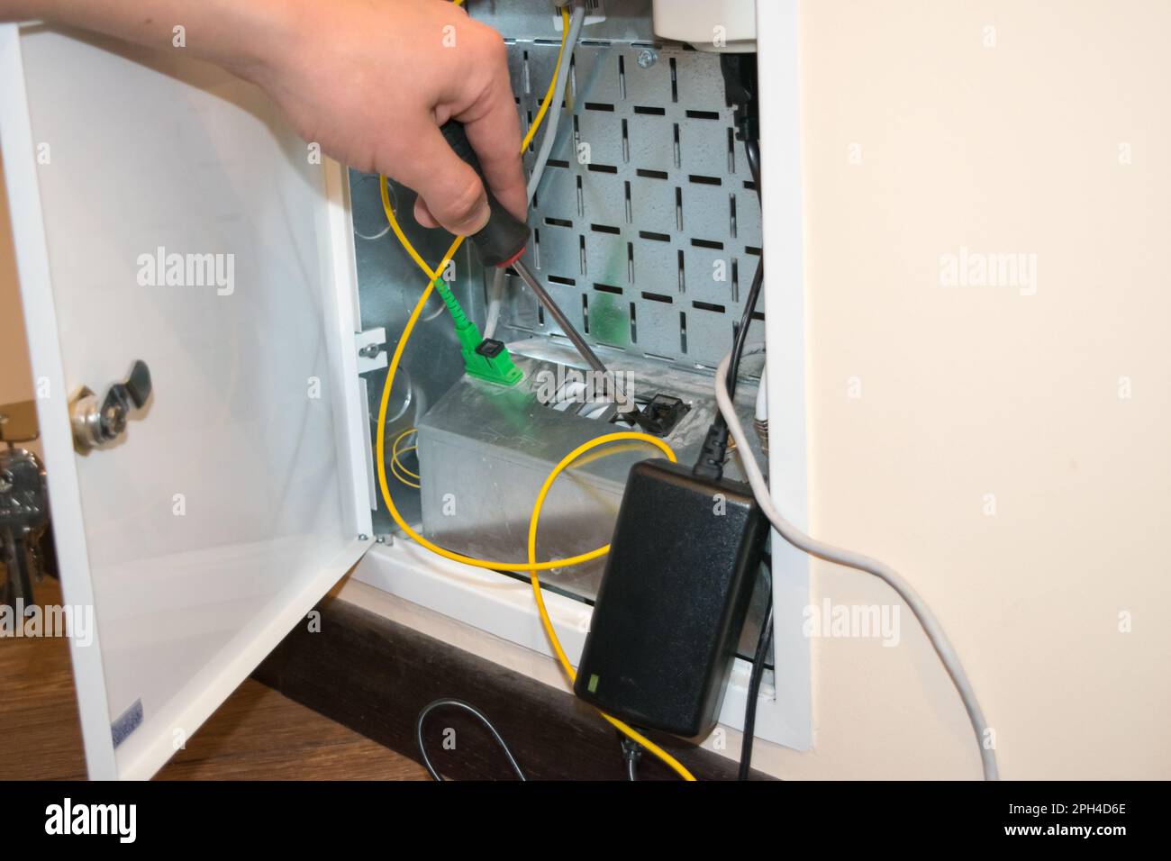 The router box is open, the human hand holds a screwdriver, there is a ...