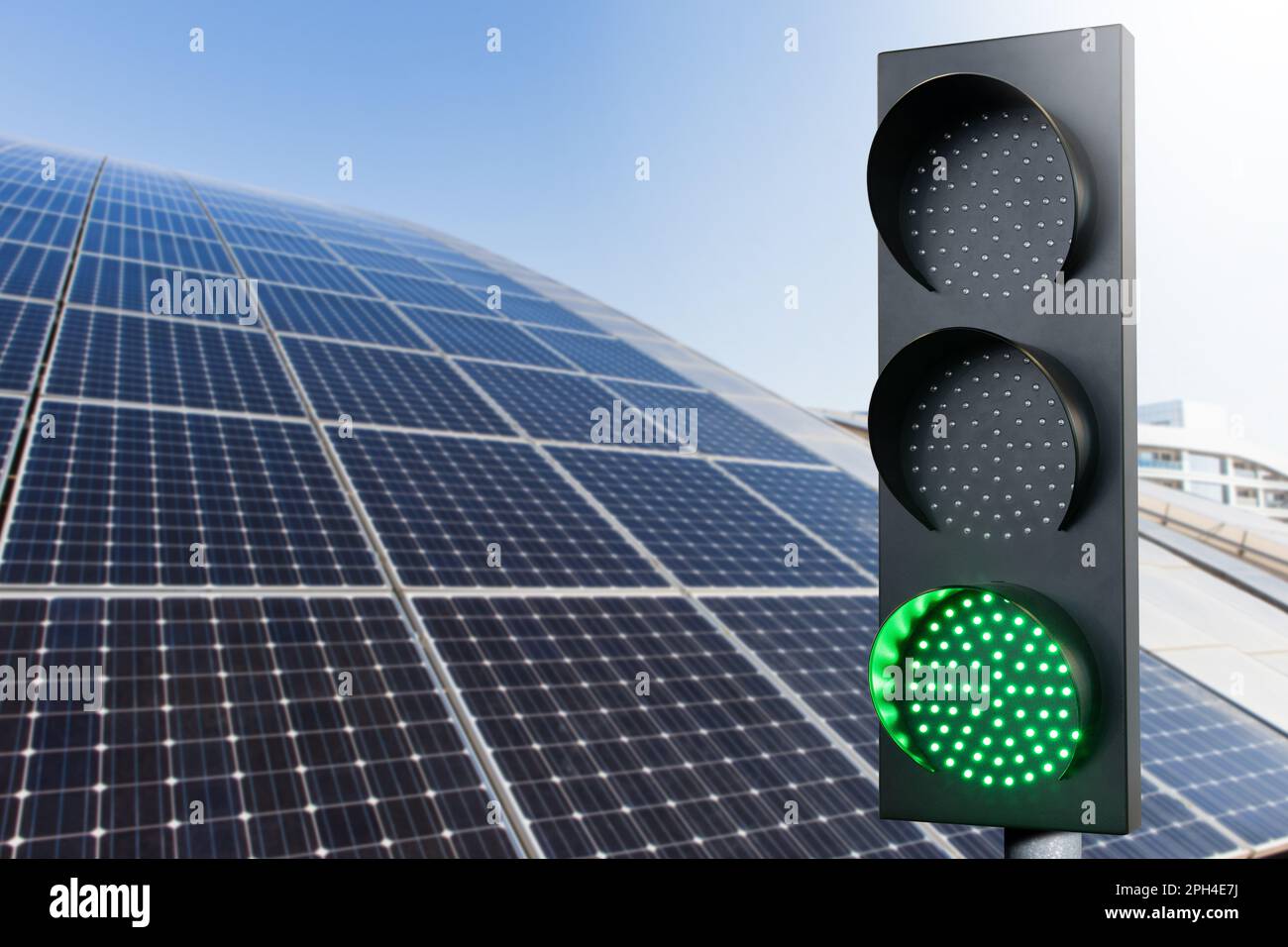 Green traffic light on a background of solar panels. Symbol of sustainable energy and development. High quality photo Stock Photo