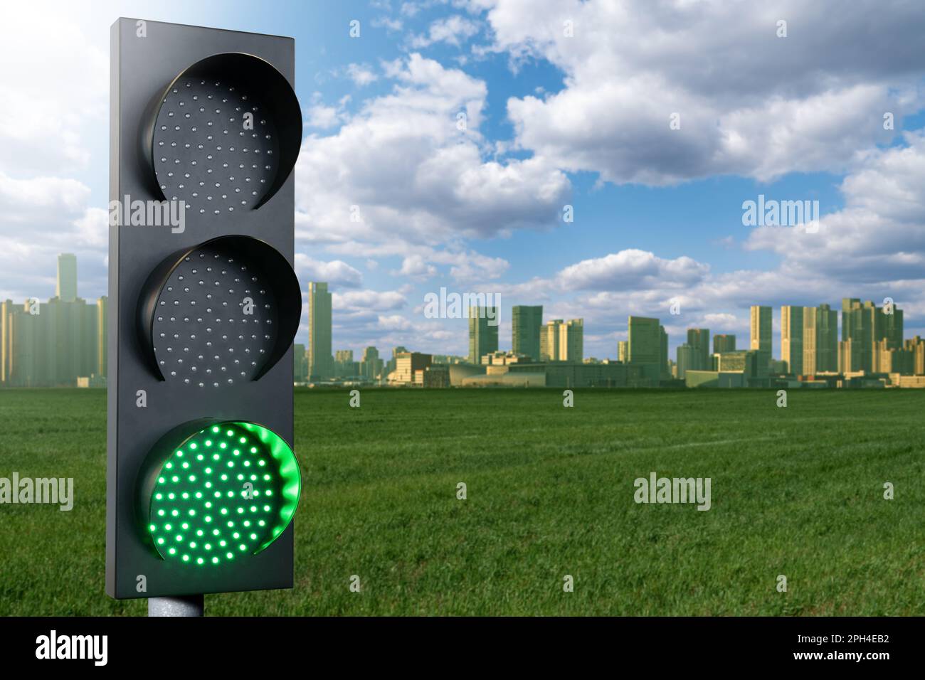 Green traffic light on a background of green city. Symbol of sustainable energy and development. High quality photo Stock Photo