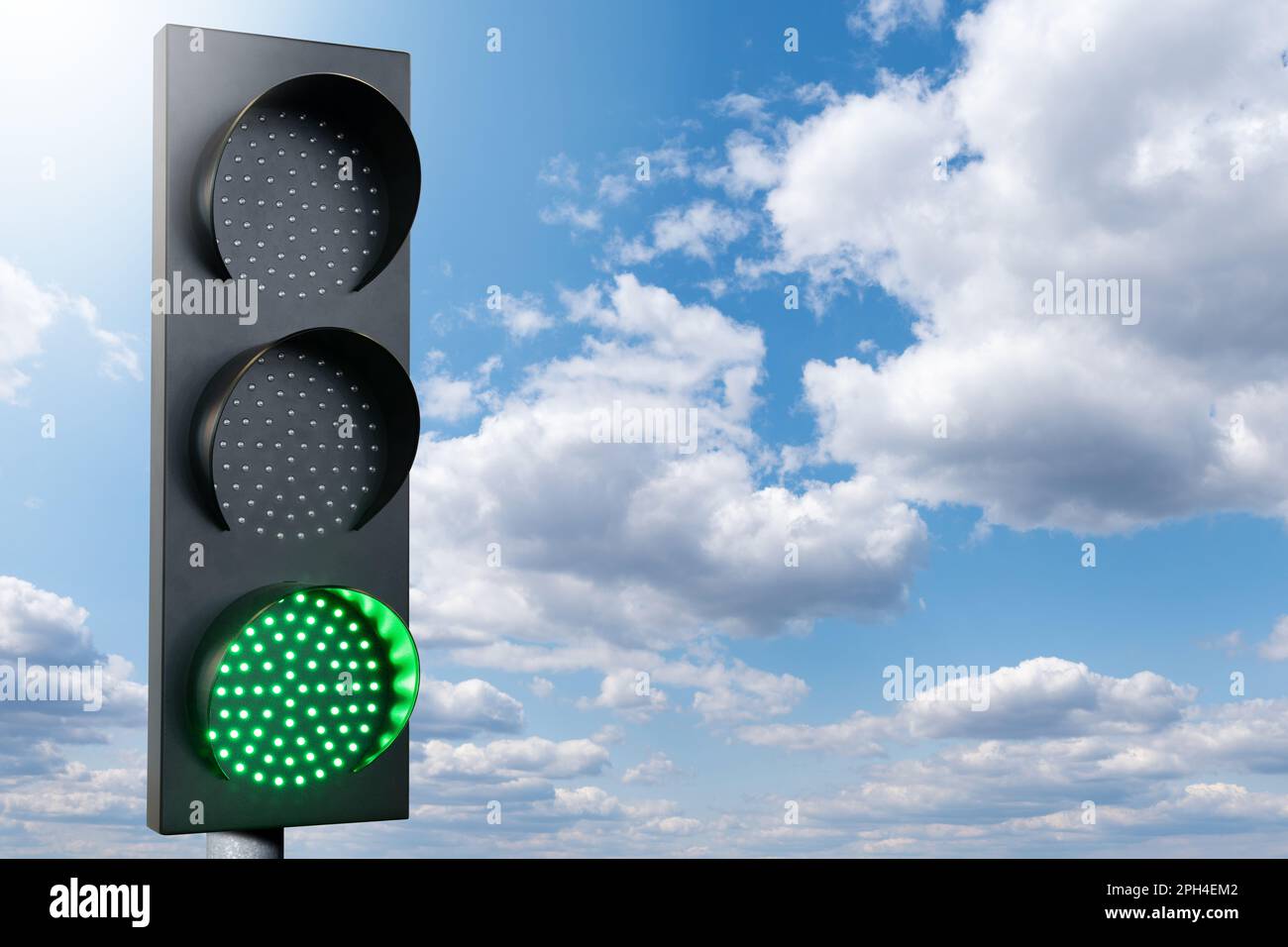 Green traffic light on a background of blue sky. Symbol of sustainable energy and development. High quality photo Stock Photo