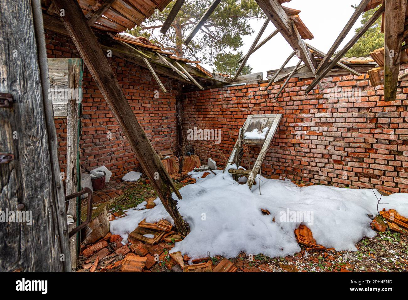 A broken window is visible leaning against a brick wall of a ruined building. Stock Photo