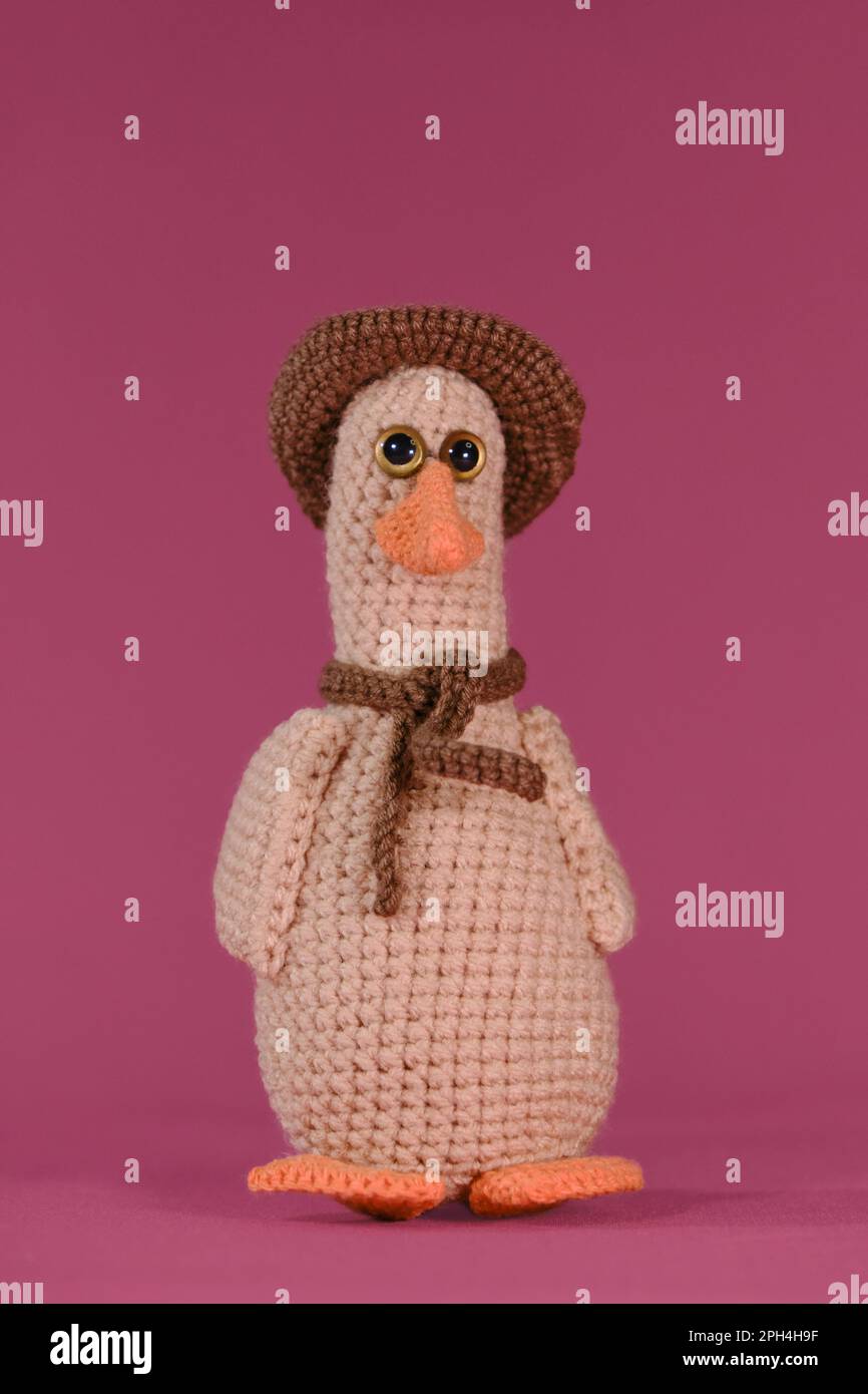 Amigurumi duck doll on pink background. Soft DIY toy made of cotton ...
