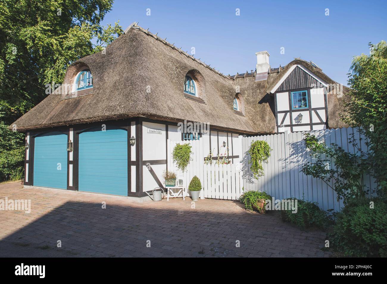 Charming house with thatched roof in Denmark Stock Photo