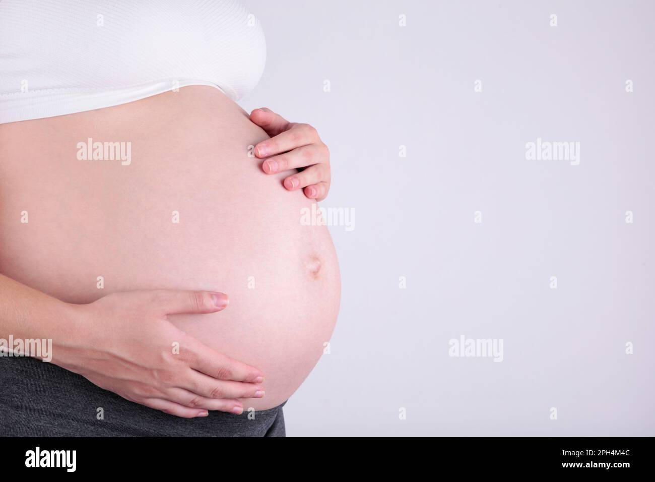 A cute pregnant belly on grey, pregnancy concept Stock Photo Alamy