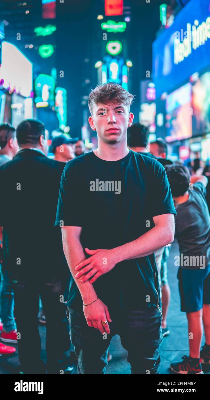 A young man standing in the middle of a bustling street in Toronto ...