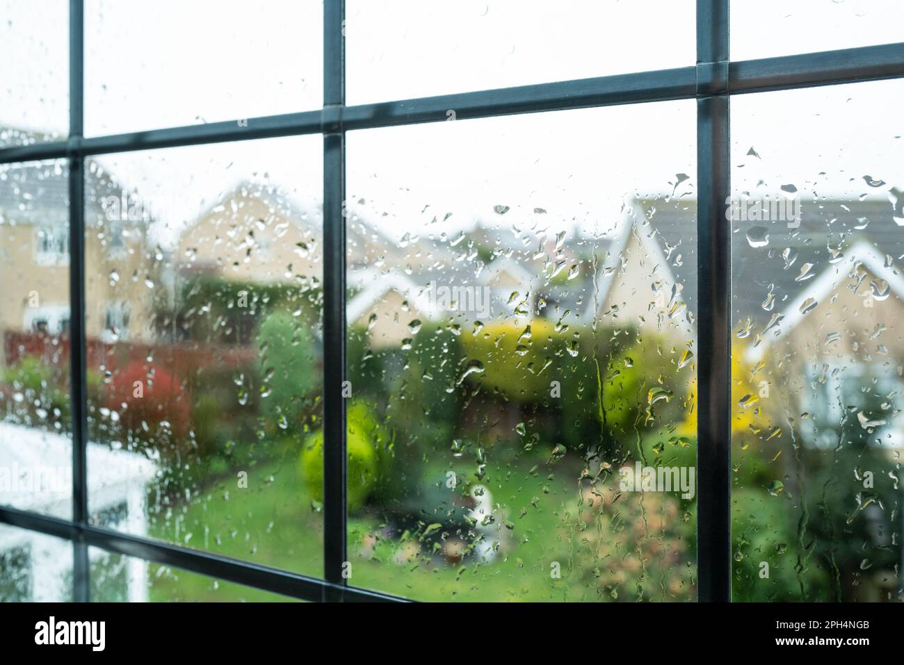 Rain drops on glass as seen from an upper floor window. Looking out to ...