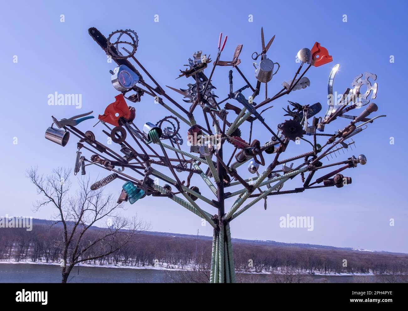 Art tree sculpture made from iron and metal materials with various gadgets on its limbs; at an overlook on the Mississippi River in Prescott, Wisconsi Stock Photo