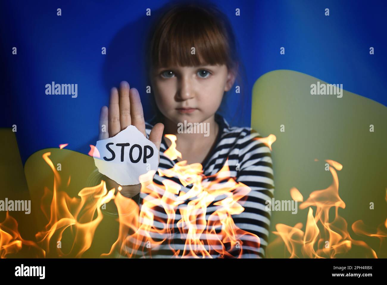 Multiple exposure of little girl with sign STOP, Ukrainian flag and fire Stock Photo