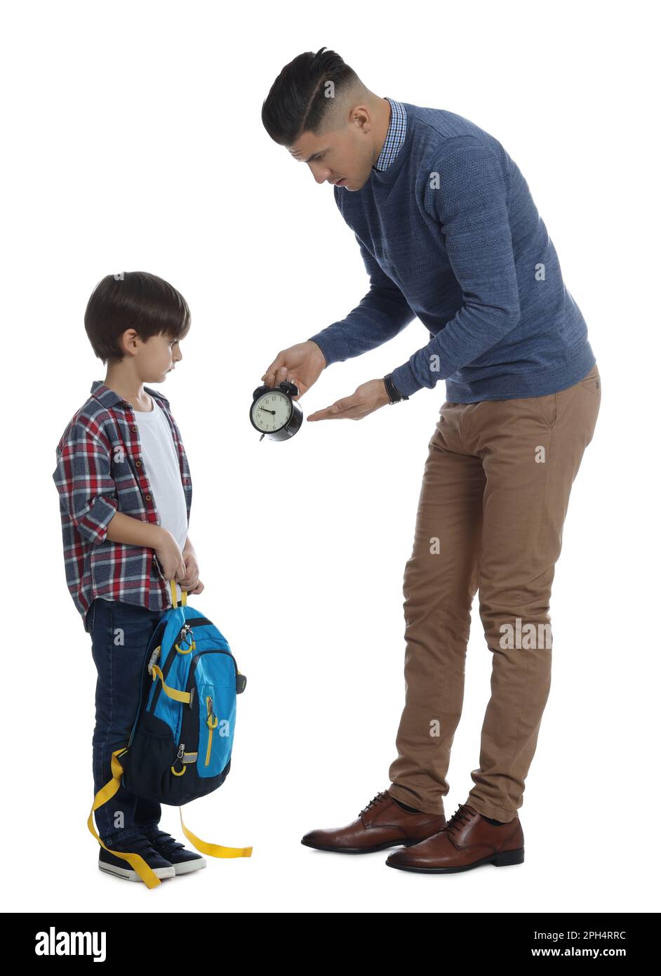 Teacher with alarm clock scolding pupil for being late against white
