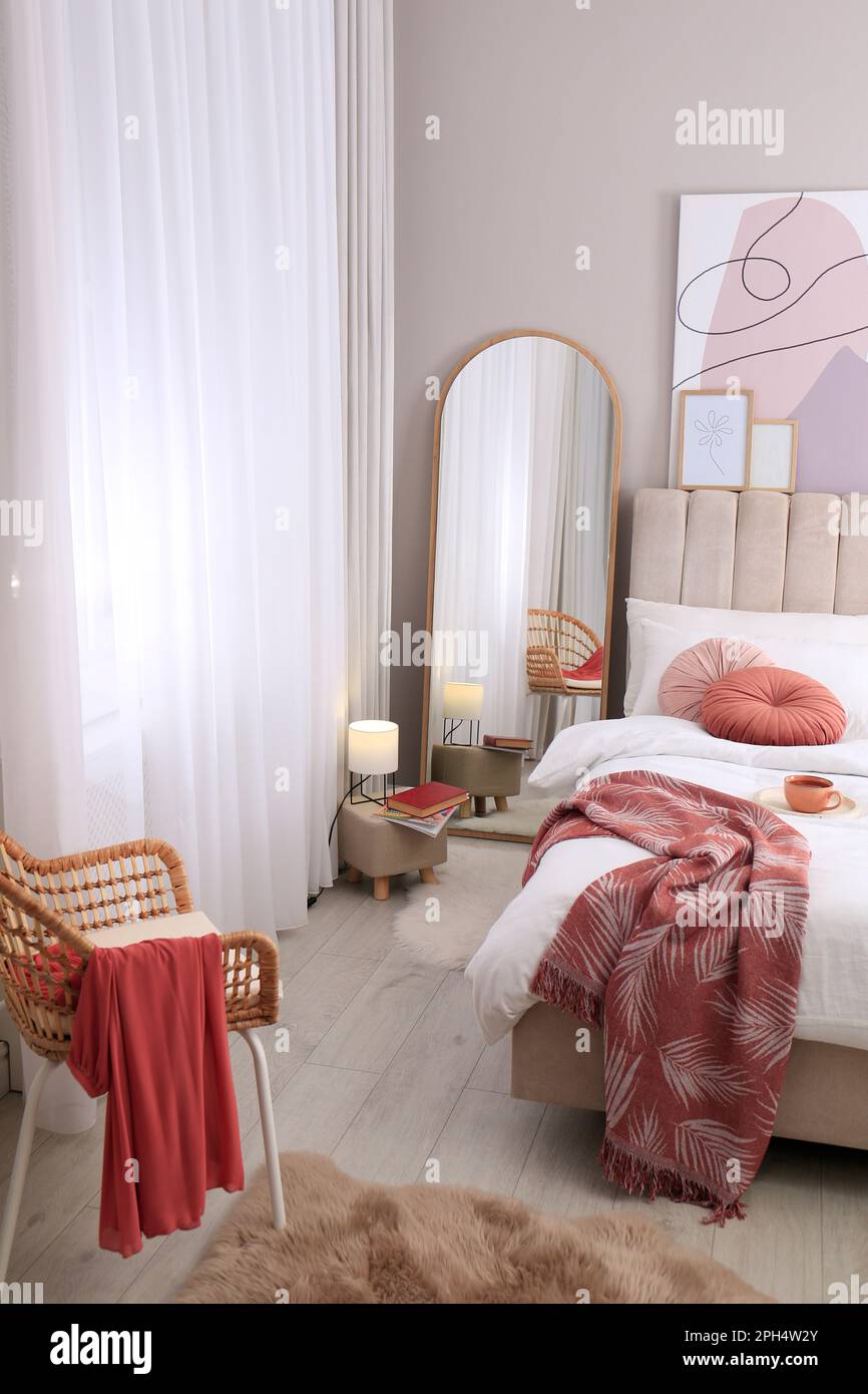 Modern bedroom interior with large stylish mirror and comfortable ...