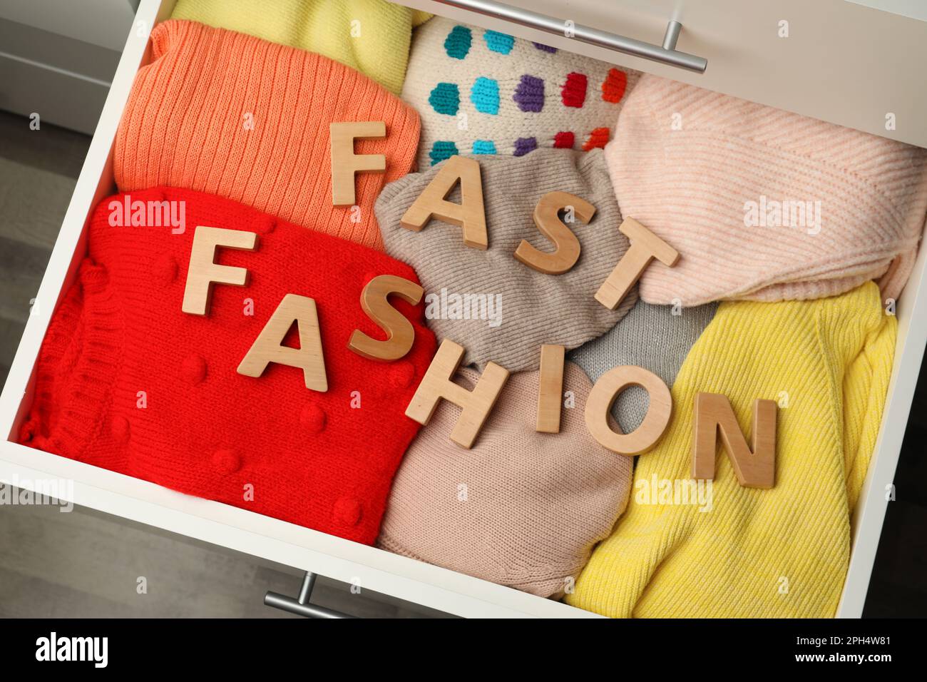 Phrase FAST FASHION made of wooden letters and different clothes in