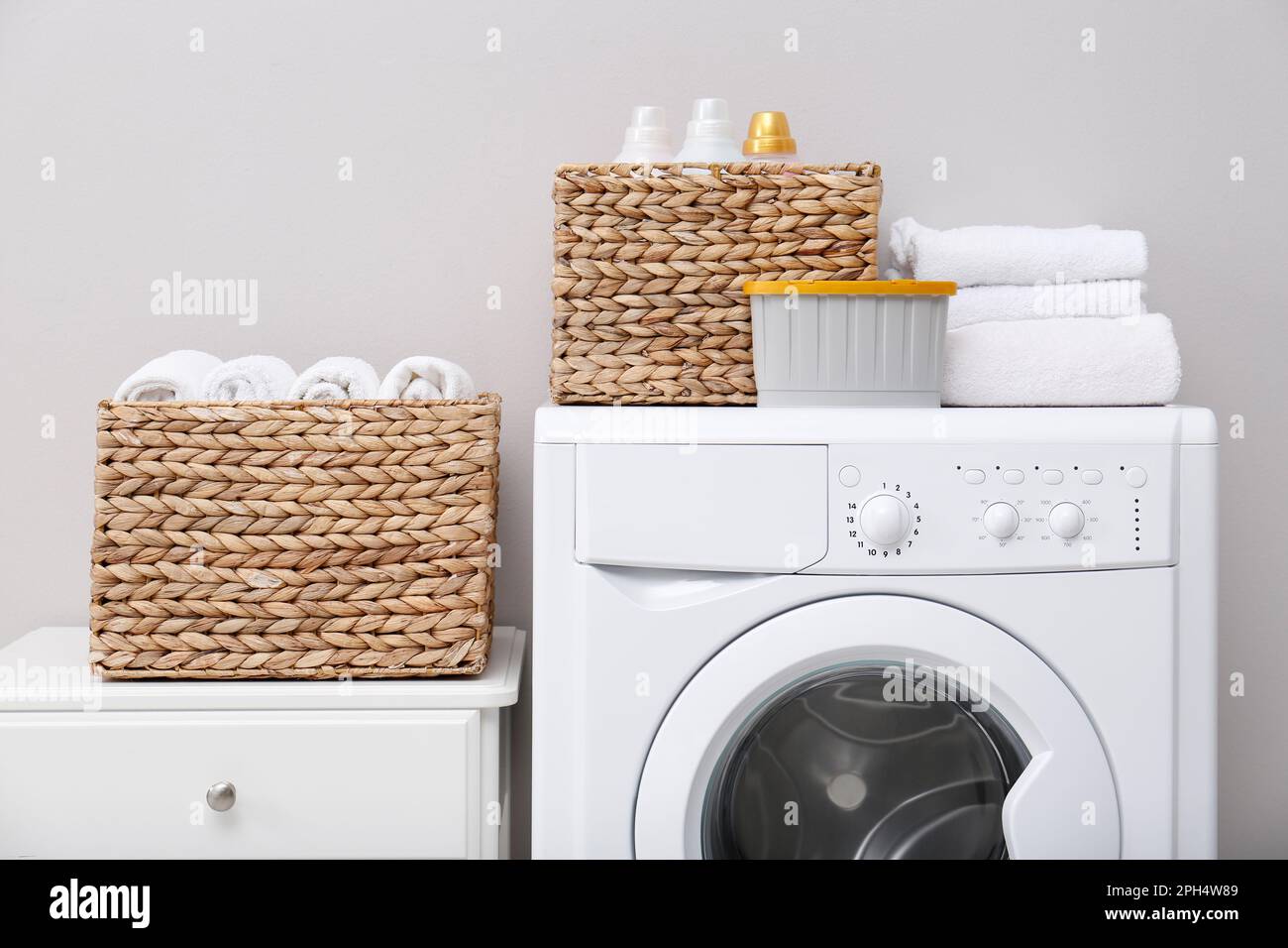 Laundry room with washing machine, detergents and clean towels. Tidying