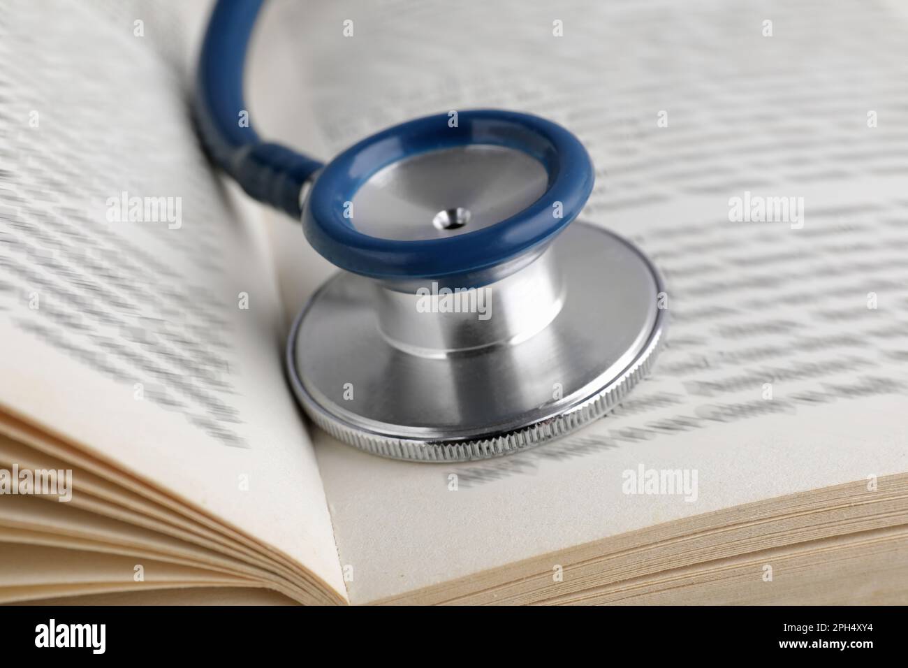 Open student textbook with and stethoscope, closeup. Medical education