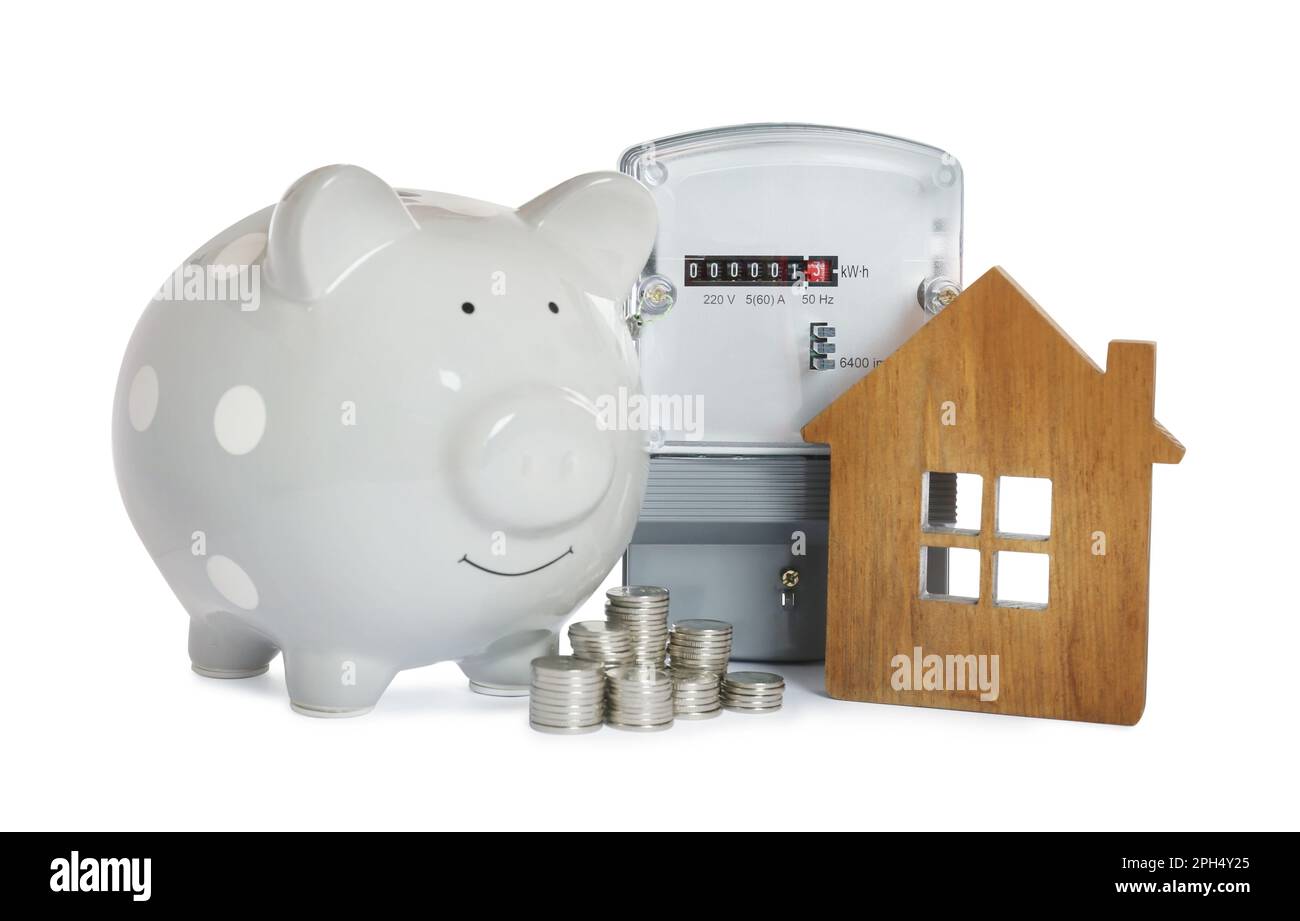 Electricity meter, house model, piggy bank and stacked coins on white ...
