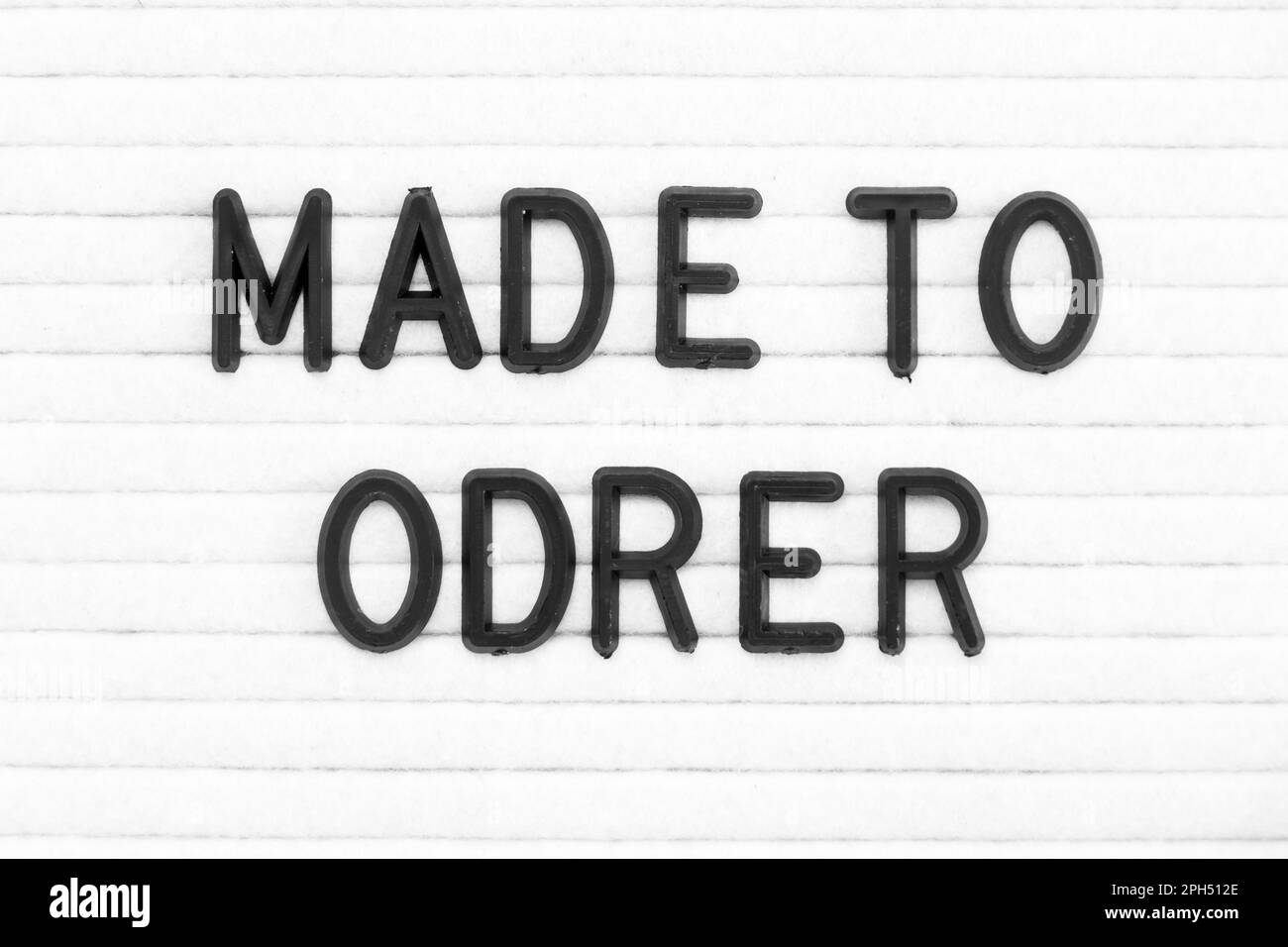 Black color letter in word made to order on white felt board background ...