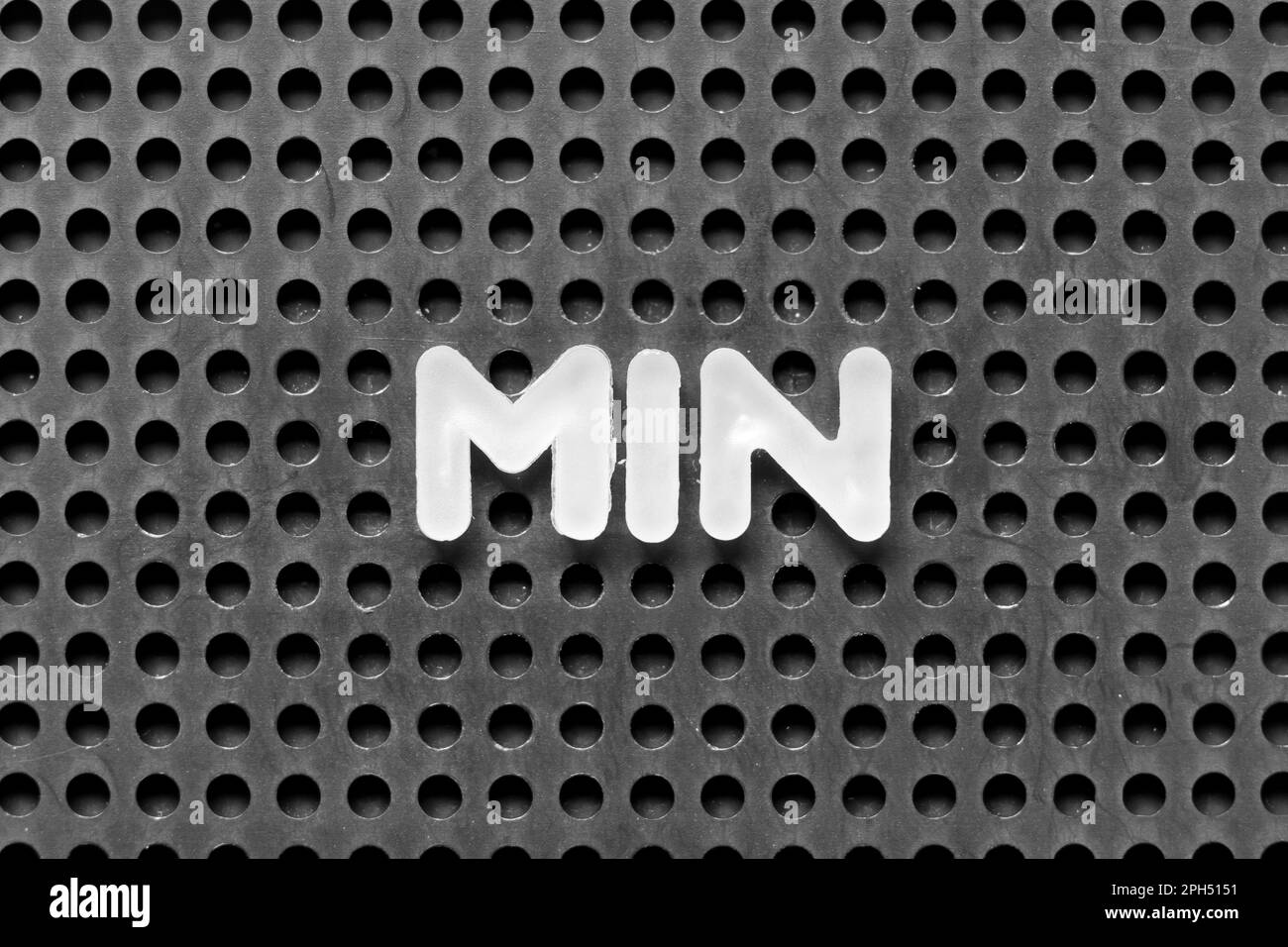 white-alphabet-letter-in-word-min-on-black-pegboard-background-stock