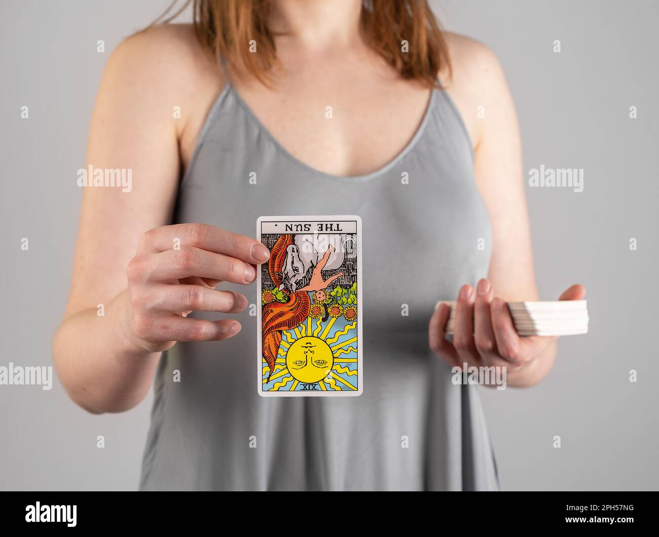 Reversed tarot card The Sun in hand fortune-teller. Divination concept. Stock Photo