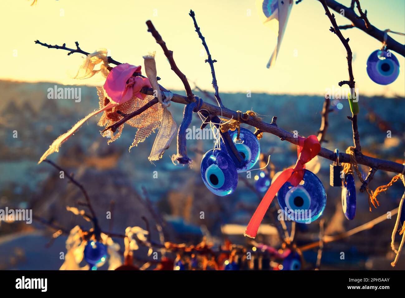 Evil eyes and ribbons on tree branches Stock Photo