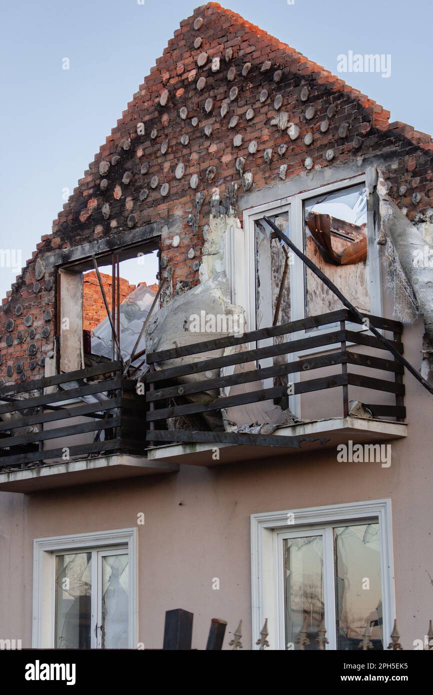 Destroyed building after russian invasion, Ukraine. Ruined facade of house. War in Ukraine. Broken windows and brick walls after missile attack. Stock Photo