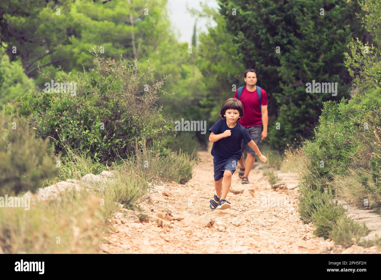 Father and Little Son Hiking in the Forest. Active Weekend Activities for Family. Male Bonding Stock Photo