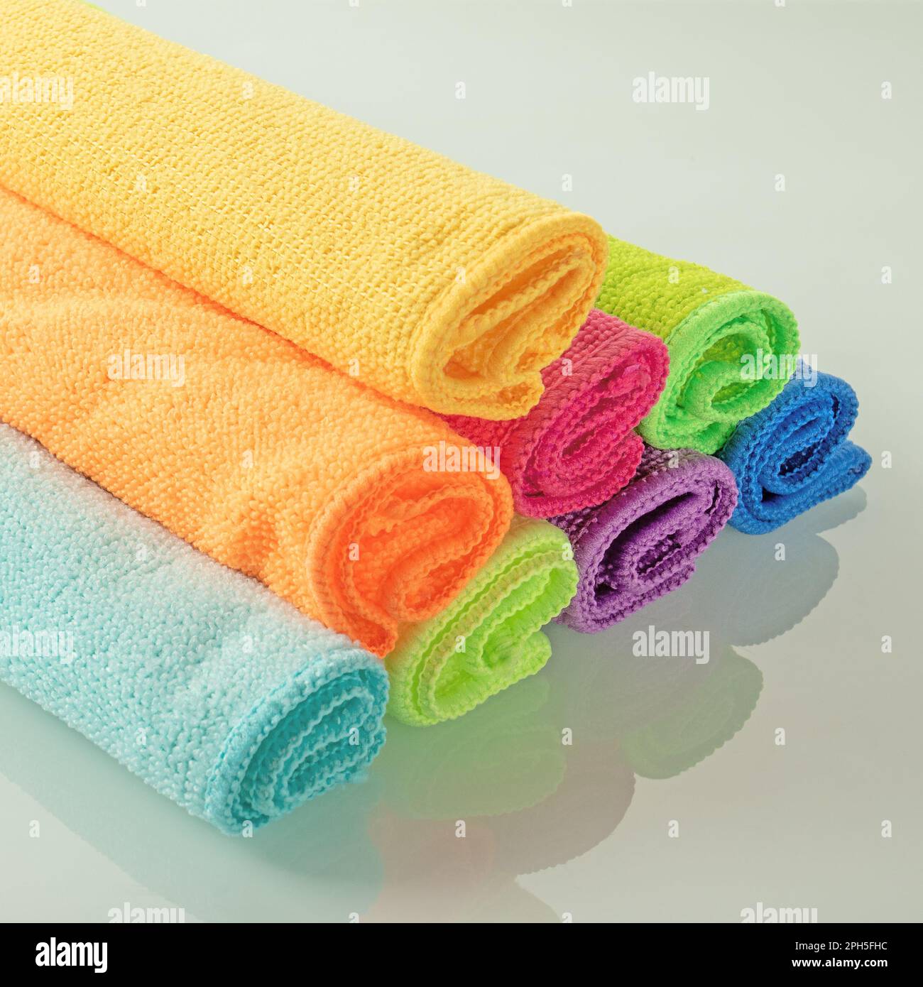 Stack of kitchen microfiber towels in bright colors on a light mirror background Stock Photo