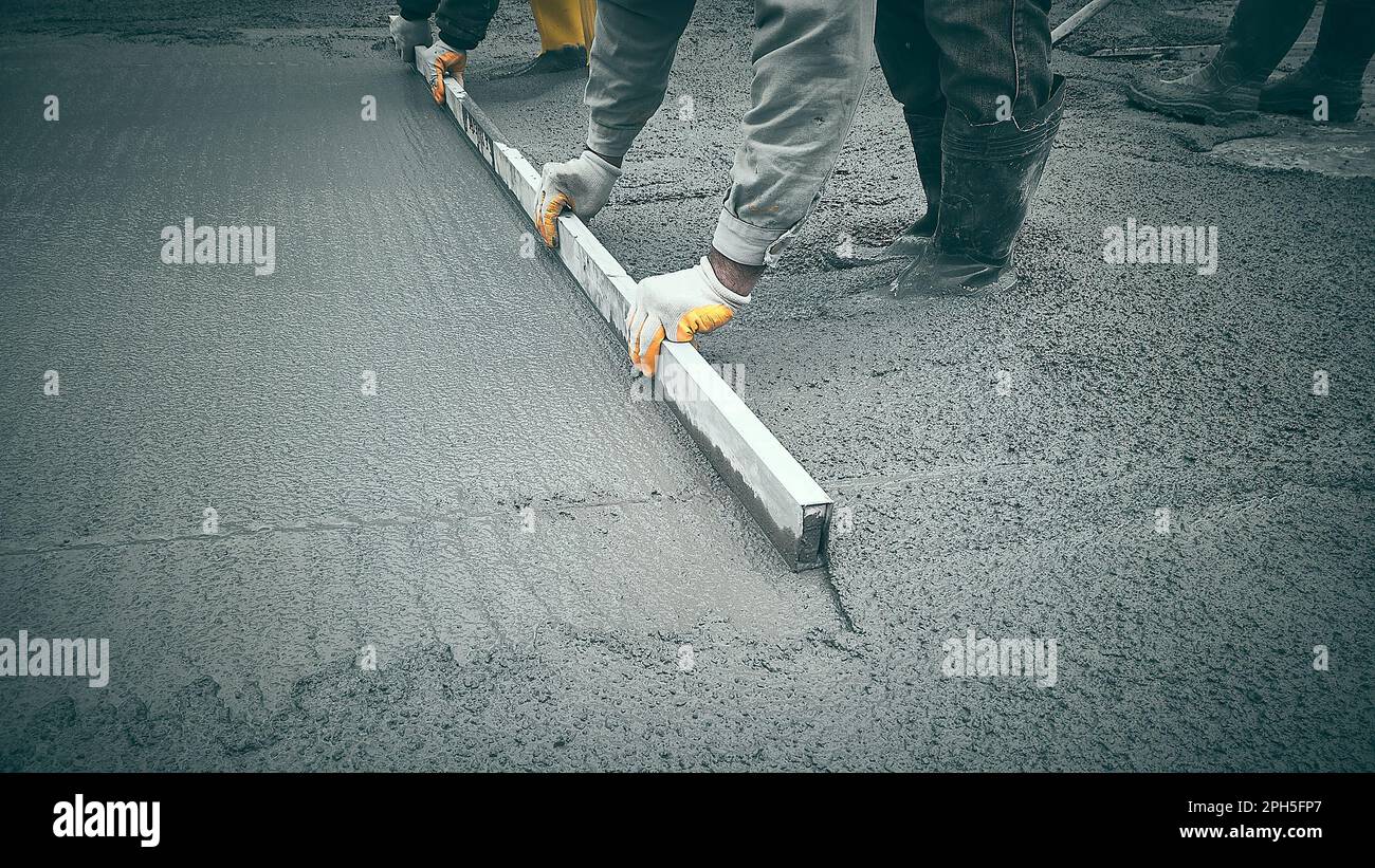 Castinplace work using trowels. Workers level cement mortar