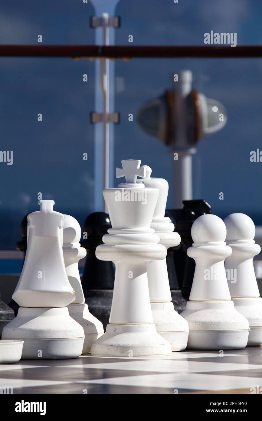 Large chess pieces, pawns, Knight, King and Queen;  on the upper deck leisure area on the Cunard cruise liner Queen Elizabeth. Stock Photo