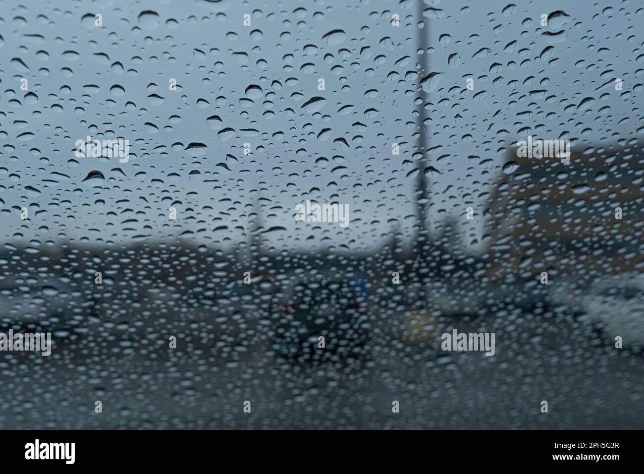 raindrops on a car windsheld in a parking lot Stock Photo