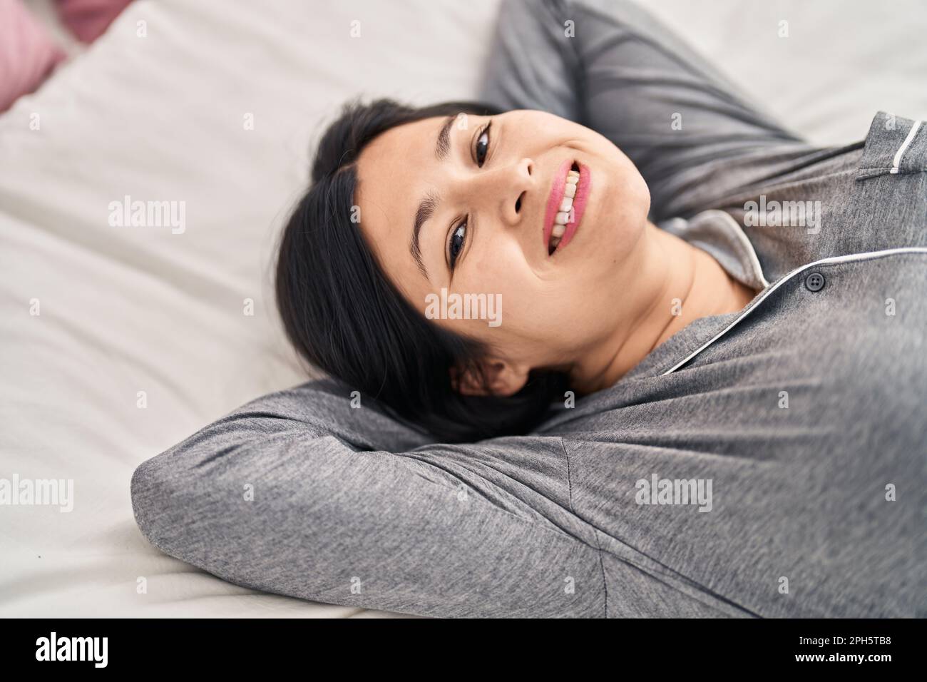 Young chinese woman smiling confident lying on bed at bedroom Stock ...