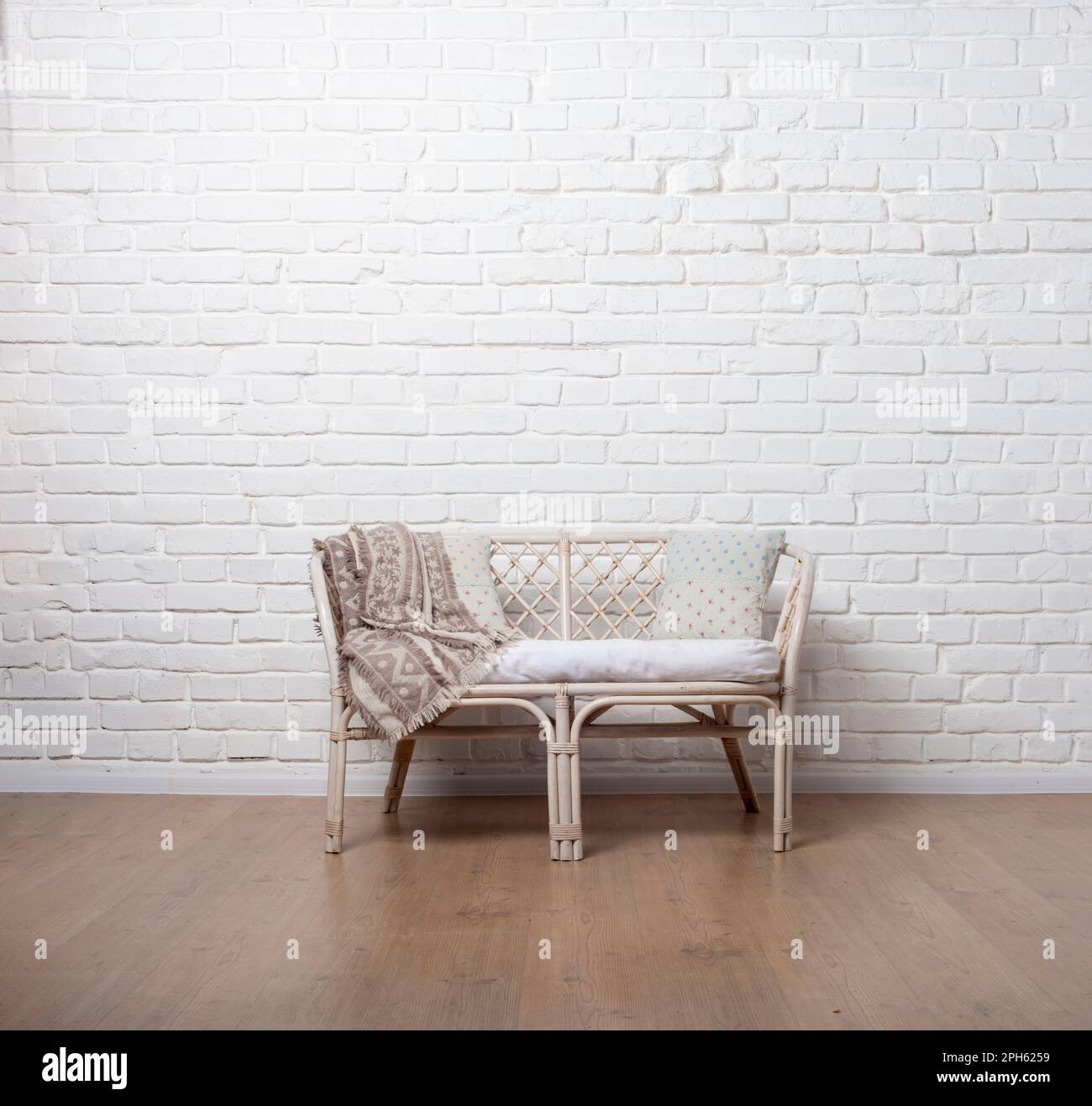 Rattan Living Room Loveseat on white brick wall background Stock Photo