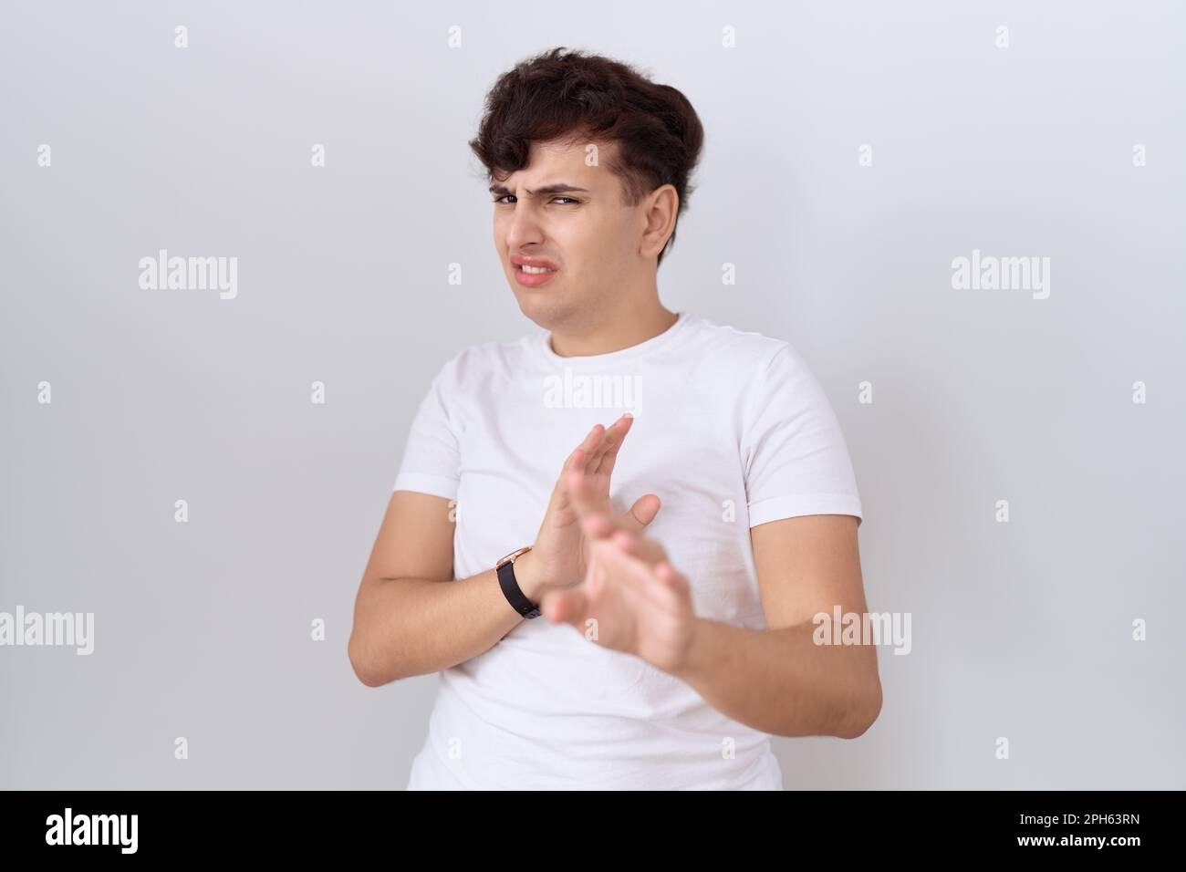 Young non binary man wearing casual white t shirt disgusted expression ...