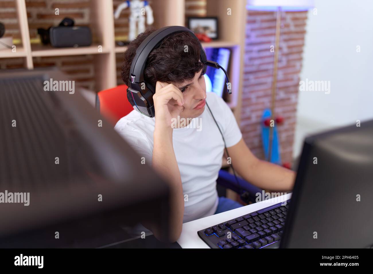 Non binary man streamer stressed using computer at gaming room Stock ...