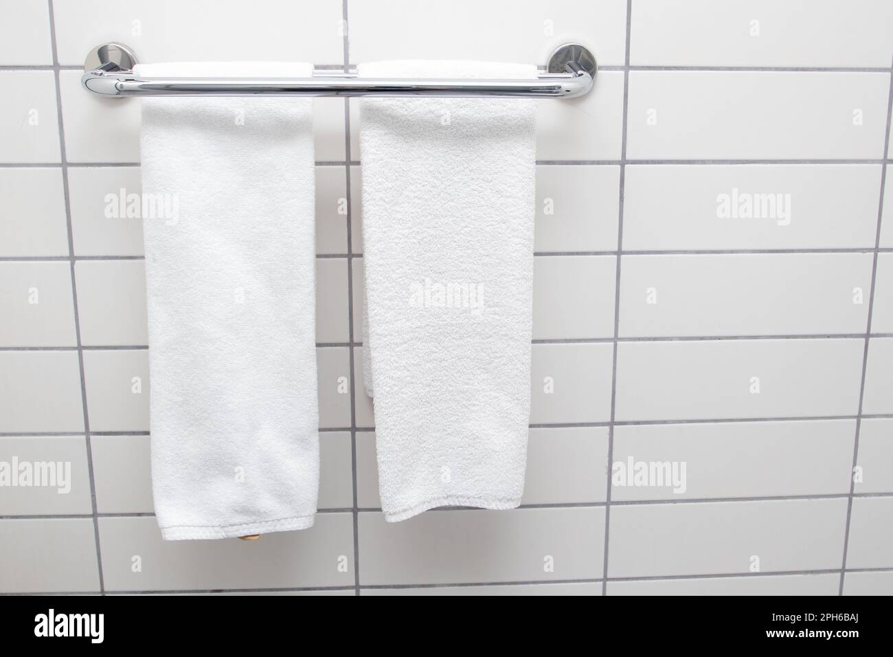 Heated towel rail on bathroom wall. White towels drying on a heated towel rail Stock Photo Alamy
