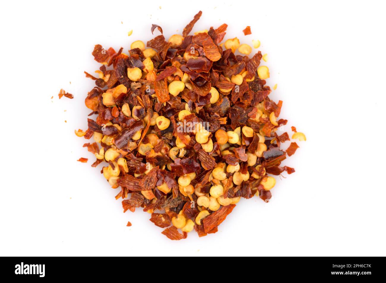 The pile of a crushed red pepper, dried chili flakes and seeds isolated