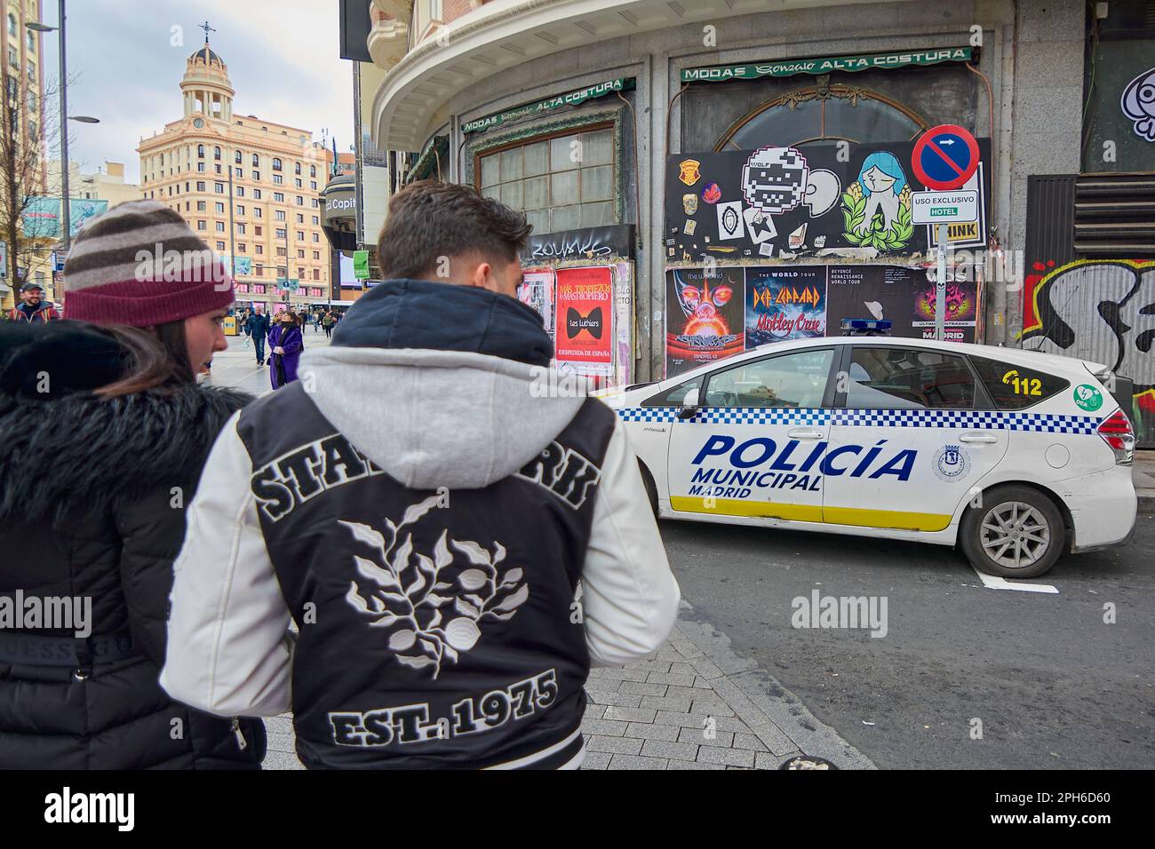 MADRID, SPAIN - March 26, 2023: Young couple looking at a parked local police car on the gran via in Madrid Stock Photo