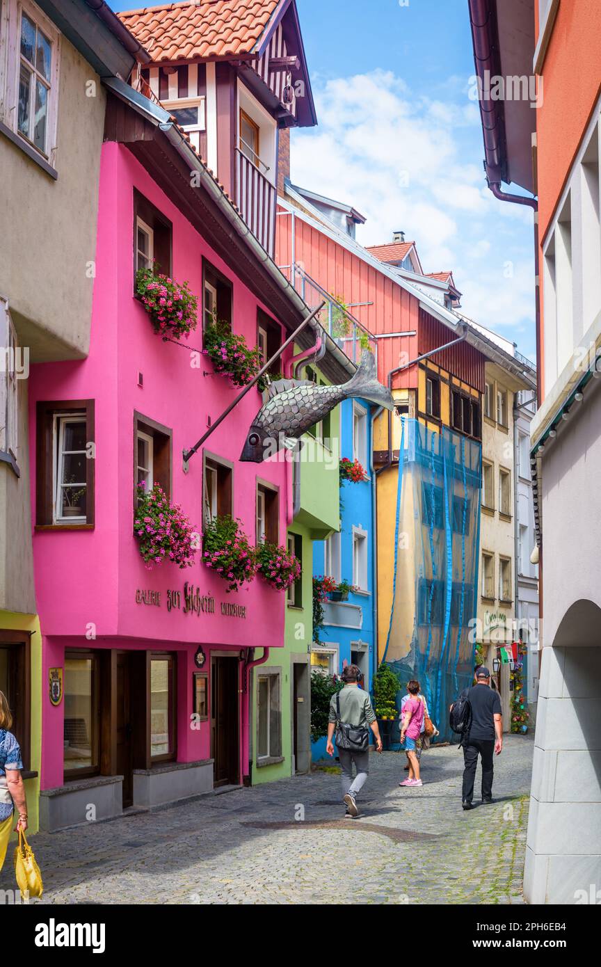 Lindau, Germany - July 19, 2019: Street with colored houses in old town of Lindau, people walk down lane past shops and restaurants in summer. This ci Stock Photo