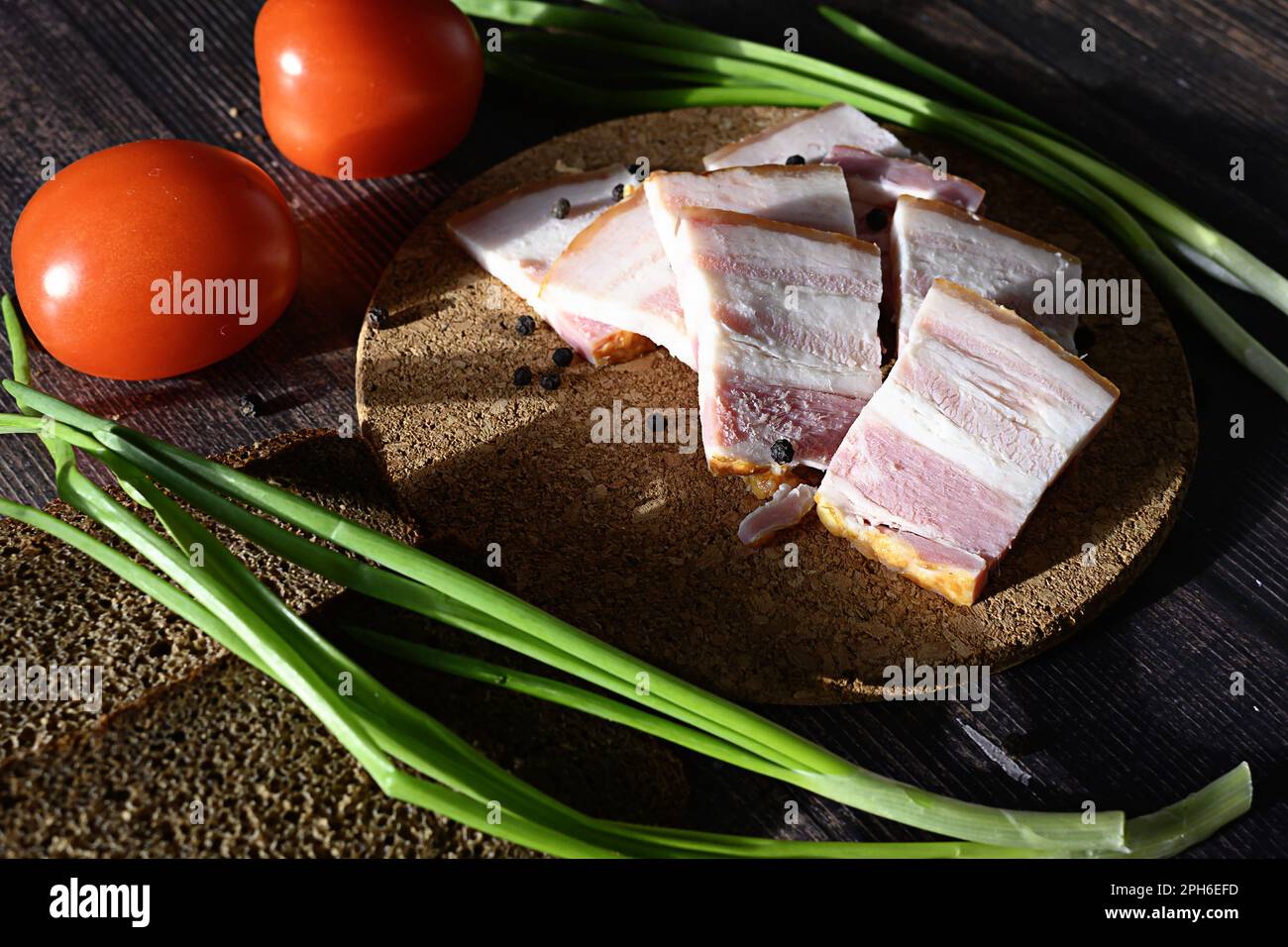 lard with black bread and green onions on a dark background, Russian