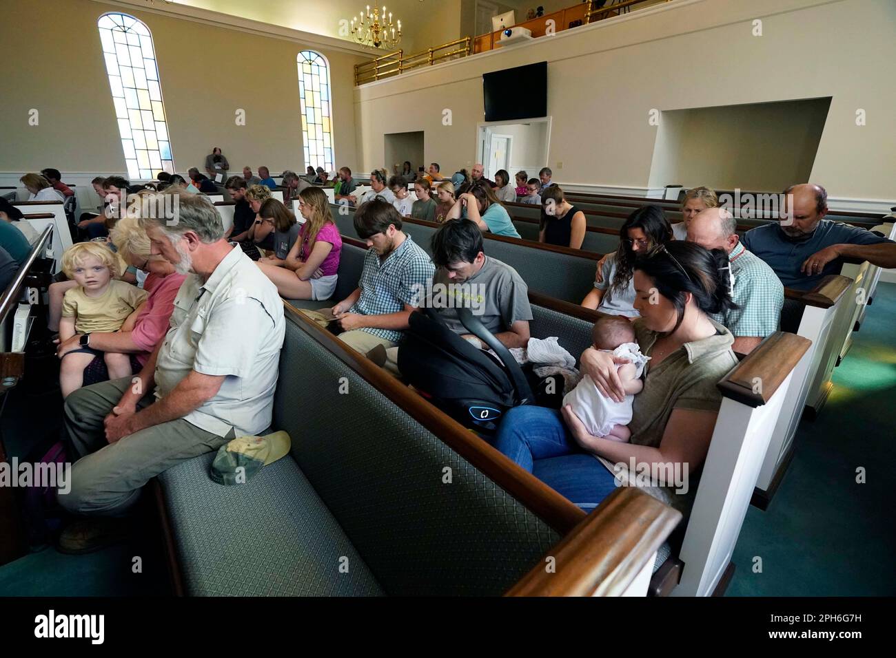 Members bow their heads in prayer during a service at the First Baptist
