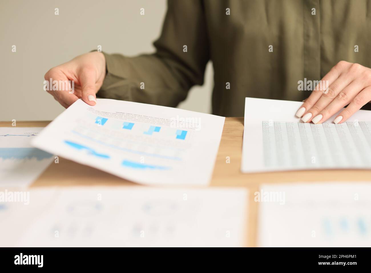 Female accountant works with statistics sitting at table Stock Photo