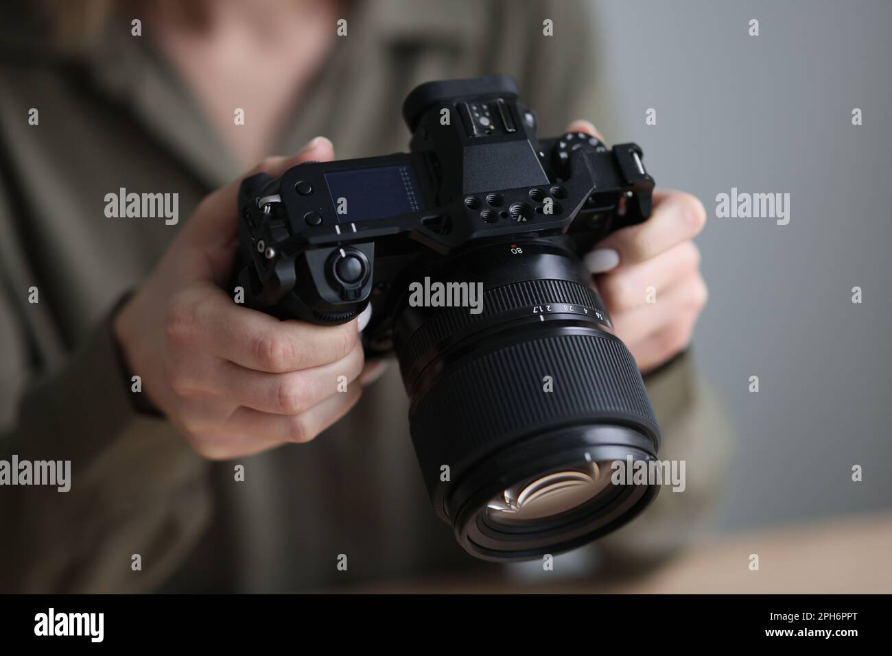 Professional photographer holds camera with big lens Stock Photo