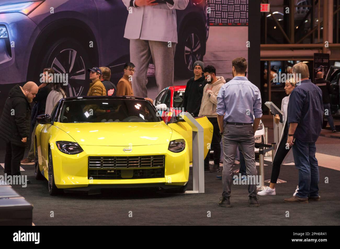Toronto, Canada - 02 25 2023: Visitors of 2023 Canadian International AutoShow surrounding yellow 2023 Nissan Z sports car, a successor of famous Stock Photo