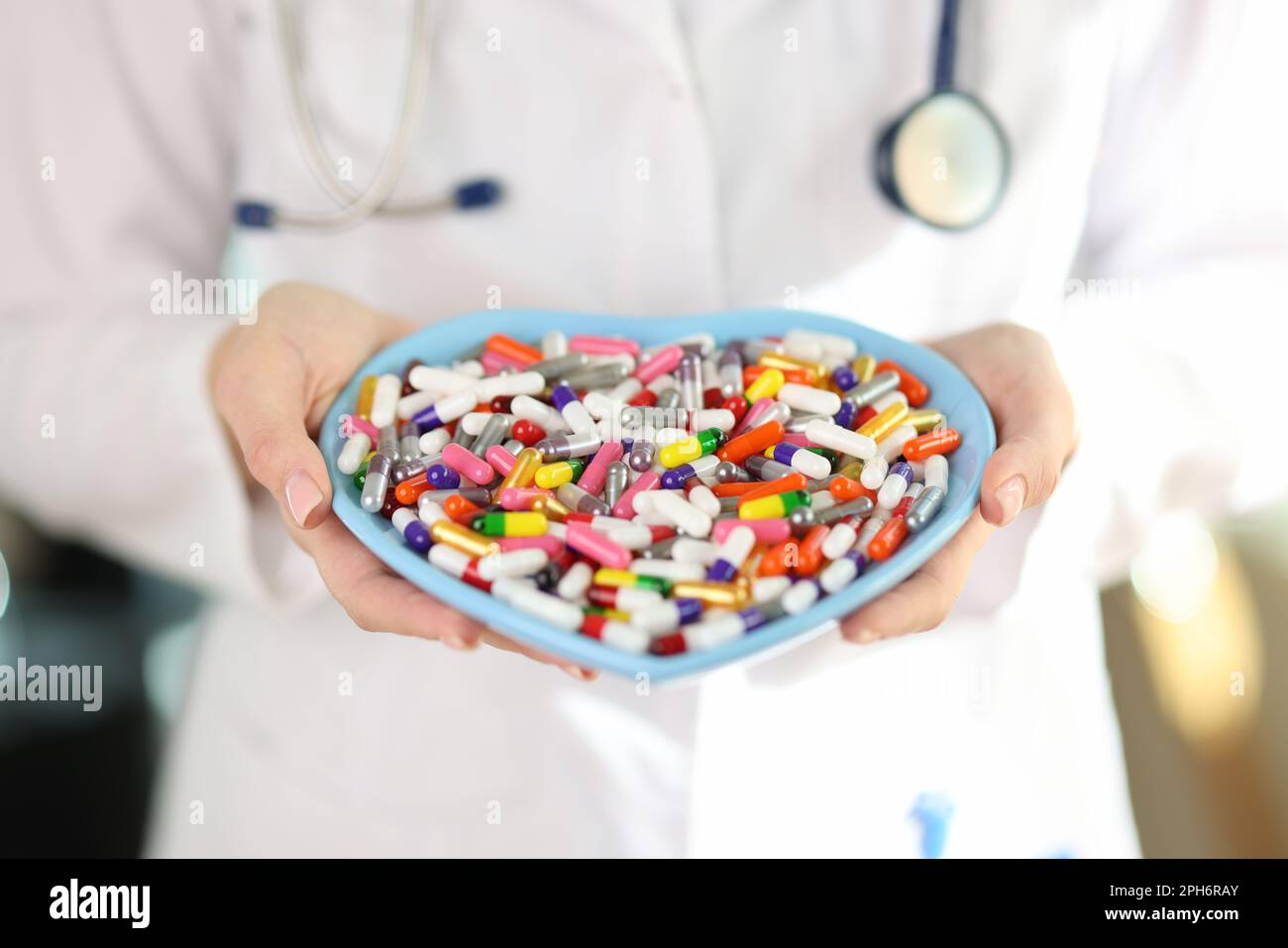 Doctor holds plate with different medications in clinic Stock Photo