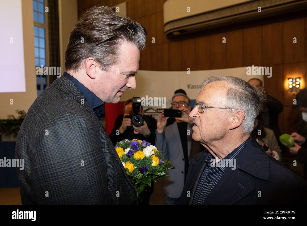 Kassel, Germany. 26th Mar, 2023. Sven Schoeller (Bündnis 90/Die Grünen) is congratulated by Hans Eichel (SPD), former finance minister, after his election as mayor of Kassel. Those eligible to vote could only vote for or against the Green Party candidate. This was because the incumbent mayor, Geselle, had withdrawn from the runoff, even though he had won the first round of voting two weeks ago with 31.5 percent of the vote. Credit: Swen Pförtner/dpa/Alamy Live News Stock Photo